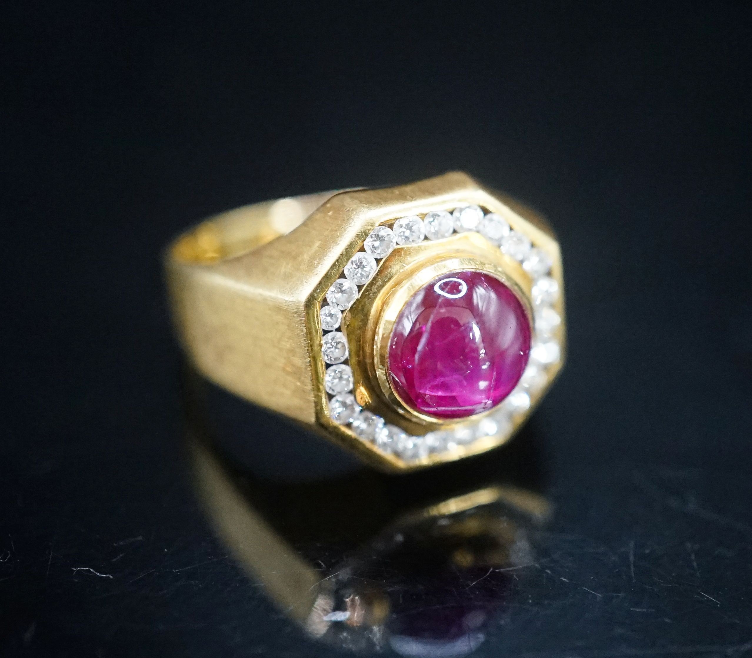 A modern continental yellow metal, cabochon ruby and diamond cluster set octagonal dress ring, size Q, gross weight 9.9 grams.